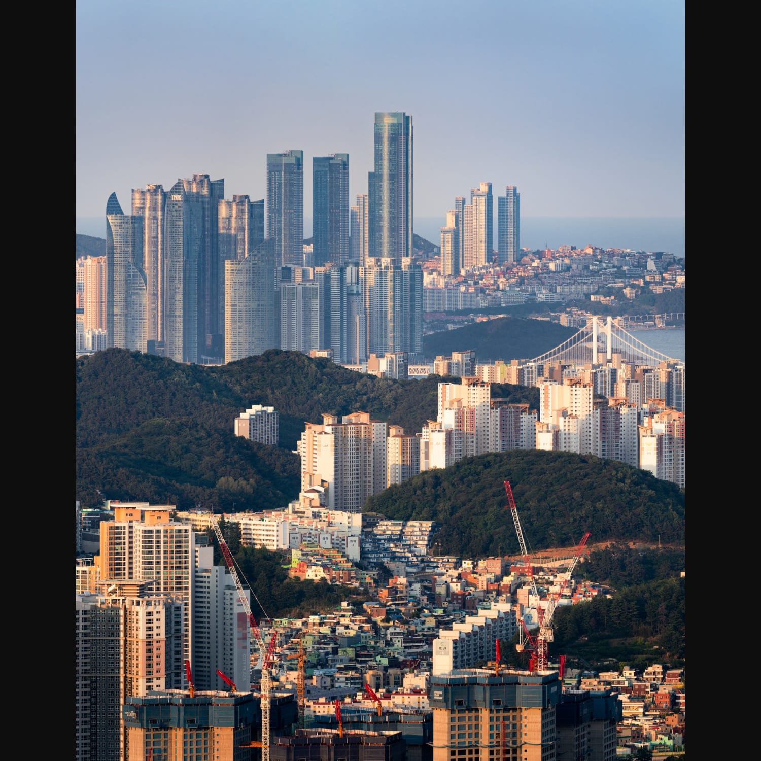 Densley packed high-rises and skyscrapers between mountains in Busan, South Korea.