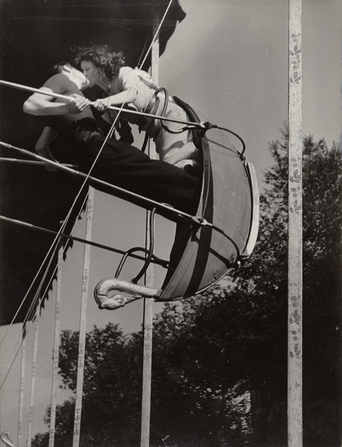 A kiss on a swing at the state fair, photographed by Brassai, 1936
