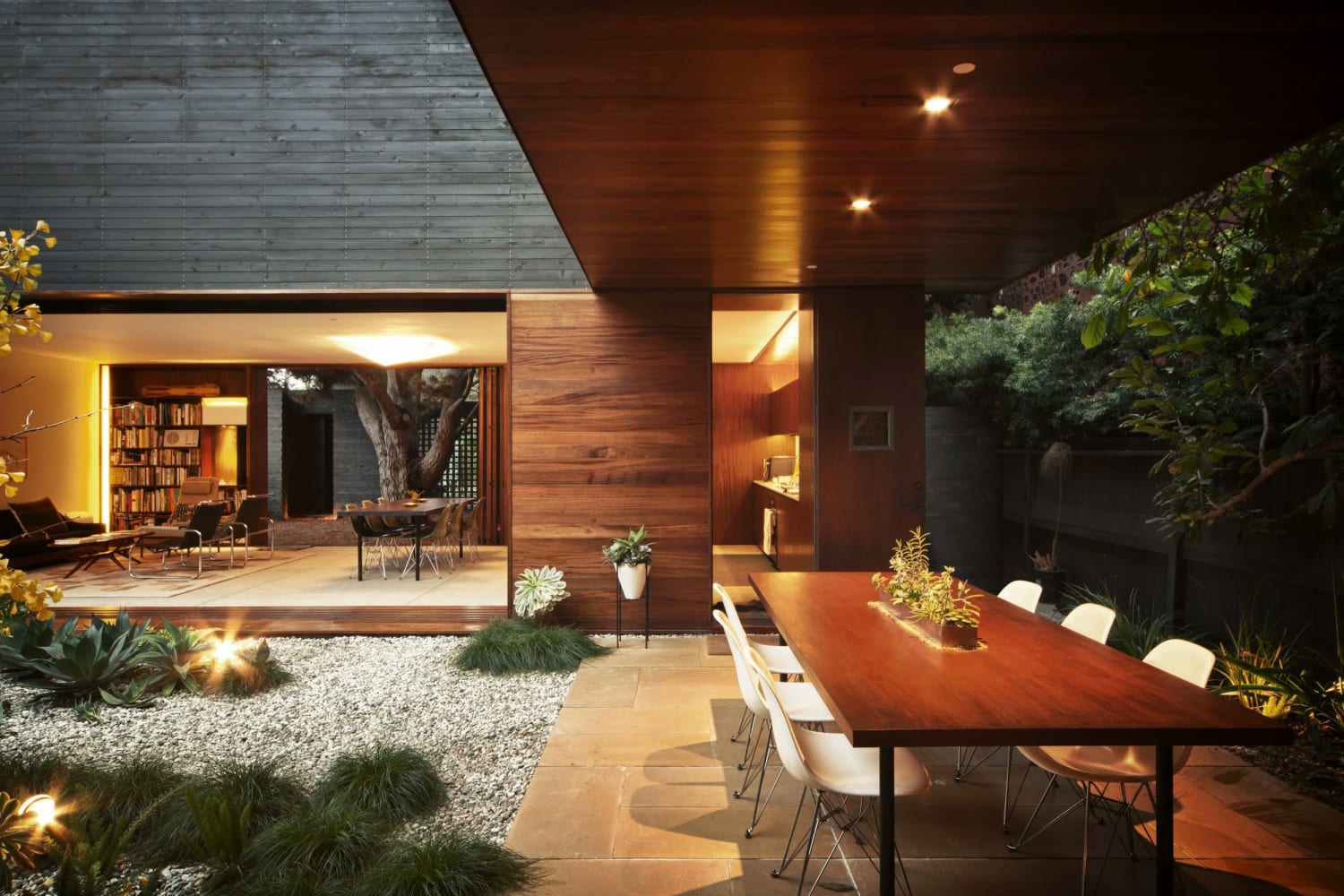 Open-air living spaces and outdoor dining patio centered around a garden in Venice, Los Angeles )