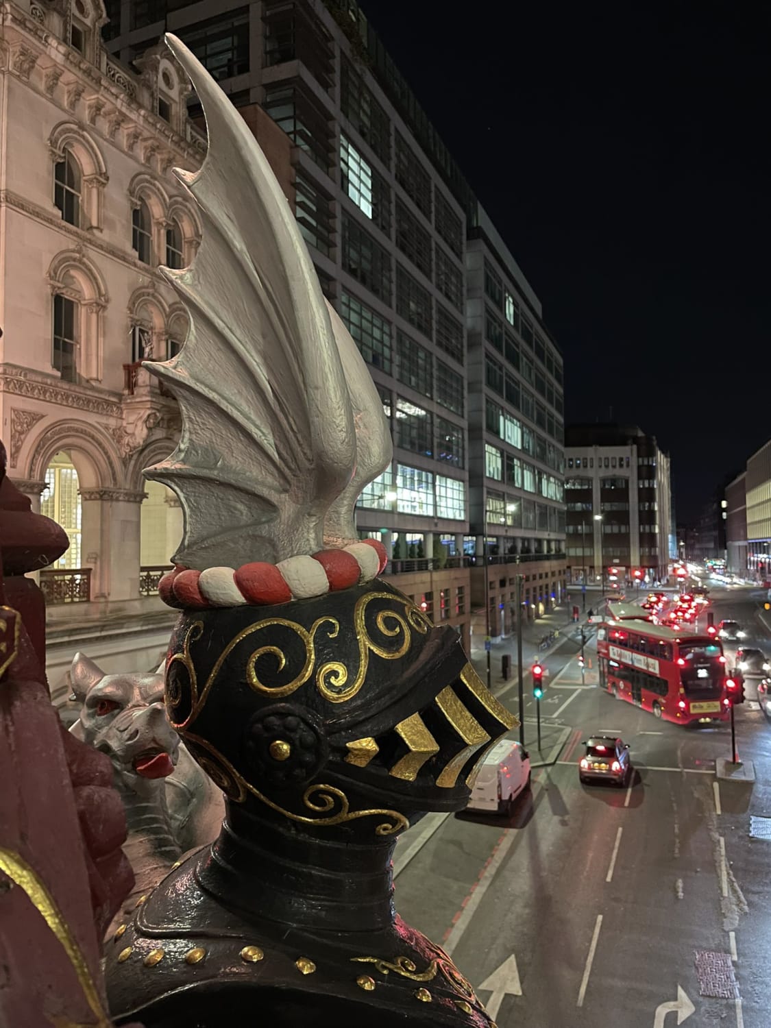 A brilliantly decorated winged helm and a silver City of London dragon with flame red tongue watch over those travelling below the Holborn Viaduct.