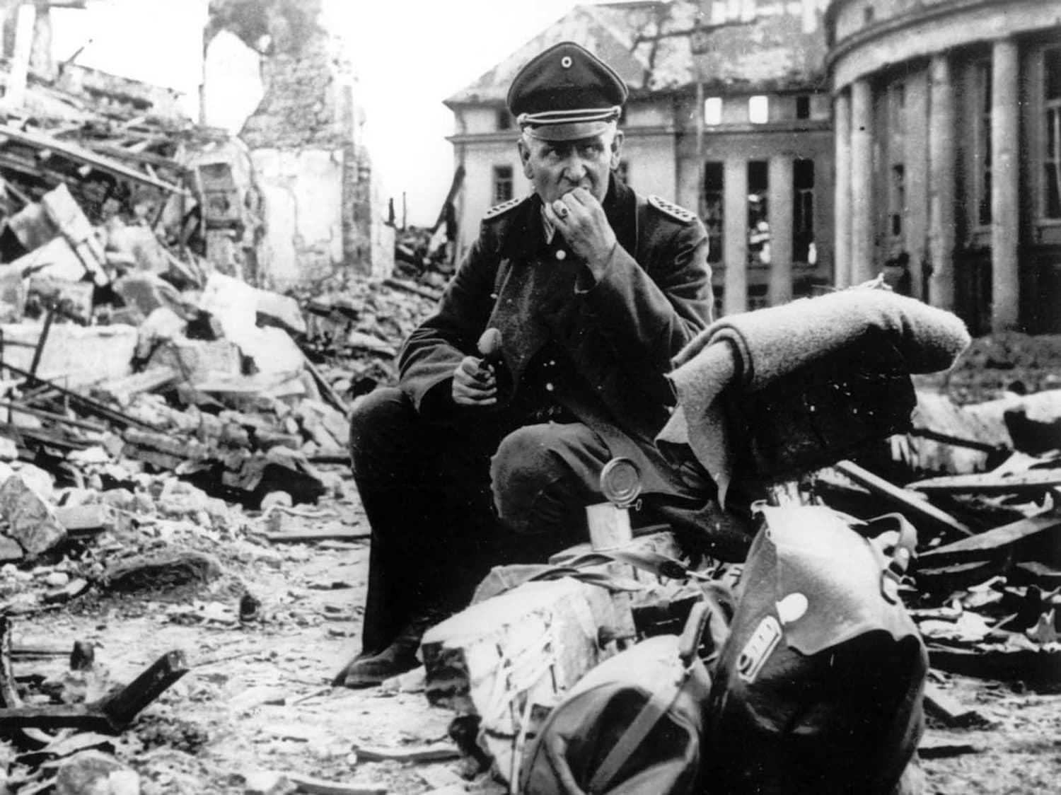 A German officer eats C-rations as he sits amid the ruins of Saarbrücken, a German city and stronghold along the Siegfried Line, in early spring of 1945.