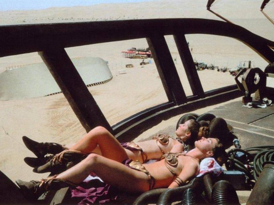 Carrie Fisher and her stunt double sunbathing on the set of "Return of The Jedi" in 1982.