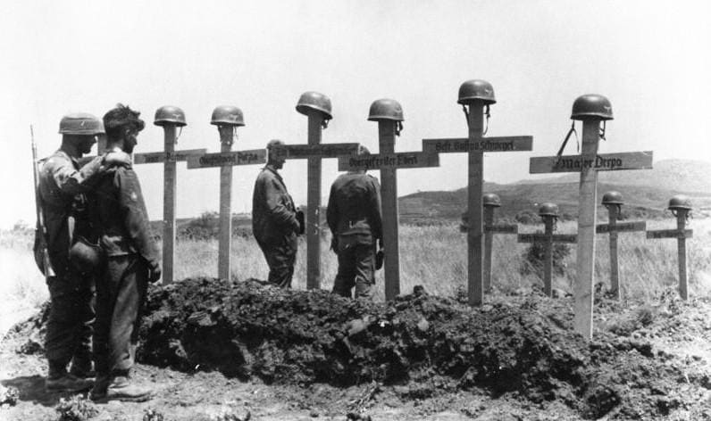 German soldiers pause before the graves of their fallen comrades Crete, May 1941.