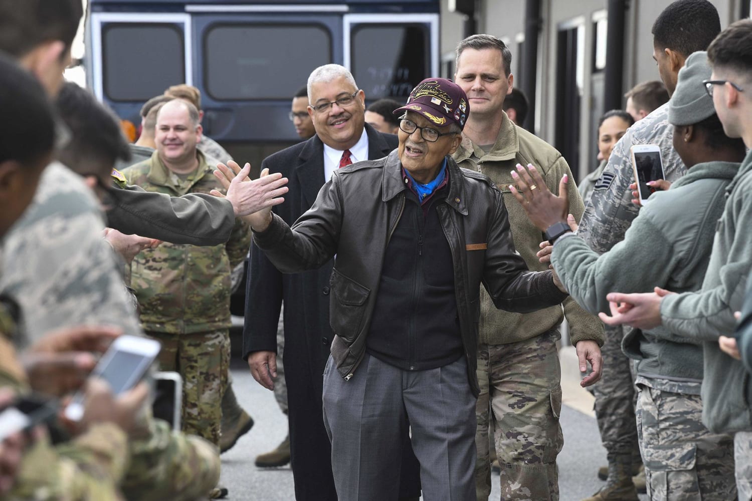 Former Tuskegee Airman, retired USAF Col. Charles McGee, center, high-fives Airmen during his visit Dec 6, 2019, at Dover AFB, Delaware