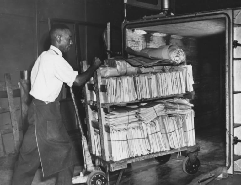 Jackie Martin came to the National Archives Building in 1946 for a photo story. She photographed many staff members working in the building, including this employee loading records into a fumigation tank. See more photos on the blog
