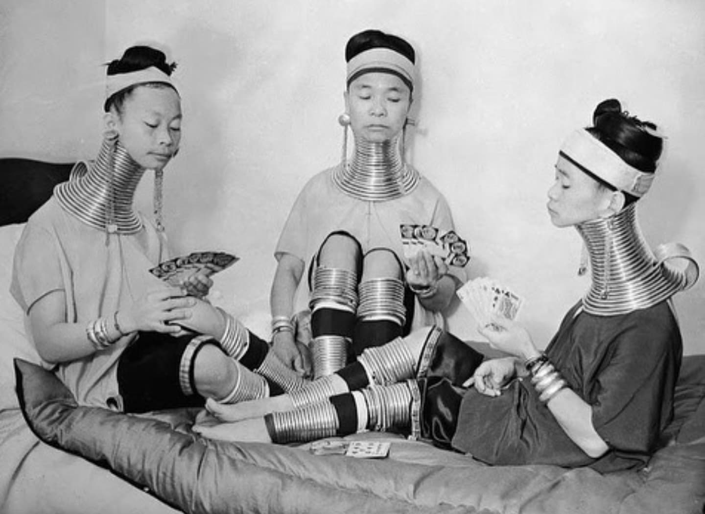Three Burmese women, members of a circus, wear brass neck and leg rings traditionally worn by Padaung women since childhood and which cannot be removed, New York, c. 1930's