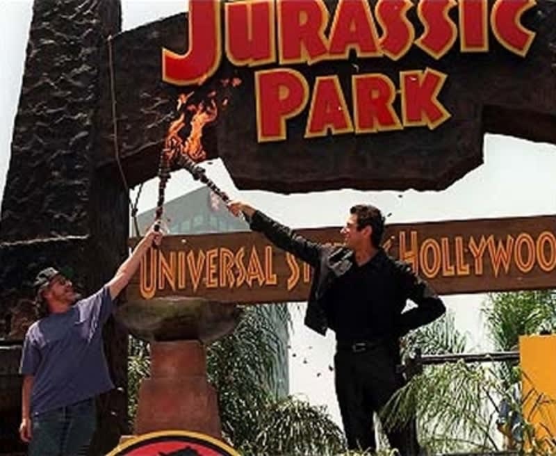 25 years ago yesterday, Jurassic Park: The Ride officially opened at Universal Studios Hollywood. Here, Steven Spielberg and Jeff Goldblum lift the torches for the ride's grand opening on June 21, 1996.