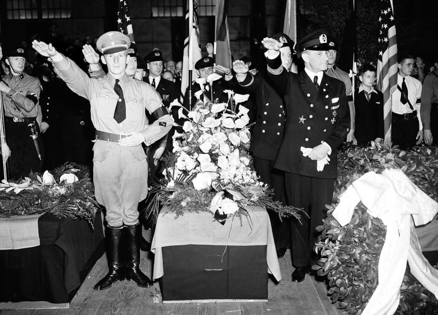 German soldiers give the salute as they stand beside the casket of Capt. Ernest A. Lehmann, former commander of the Zeppelin Hindenburg, New York City, May 11 1937