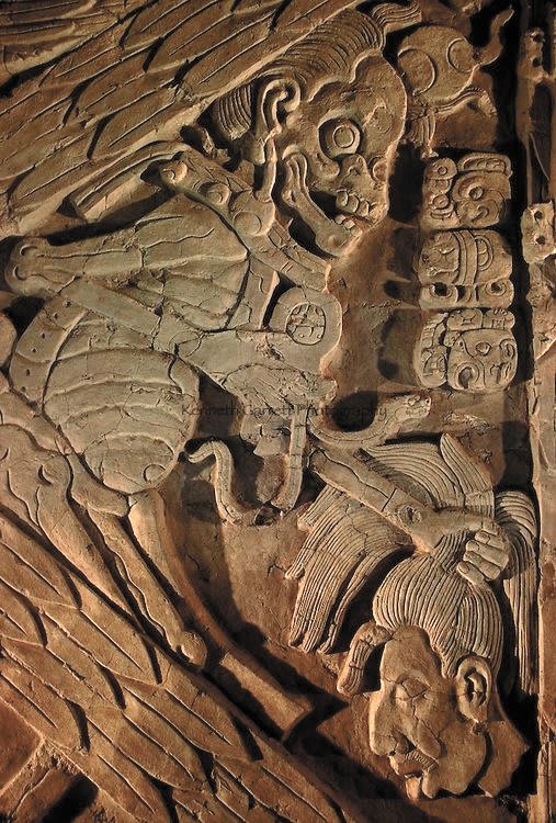 A carved scene from the underworld depicting the Maya god of death holding a severed human head. Located at the archaeological site of Toniná in Mexico, 790-840 CE
