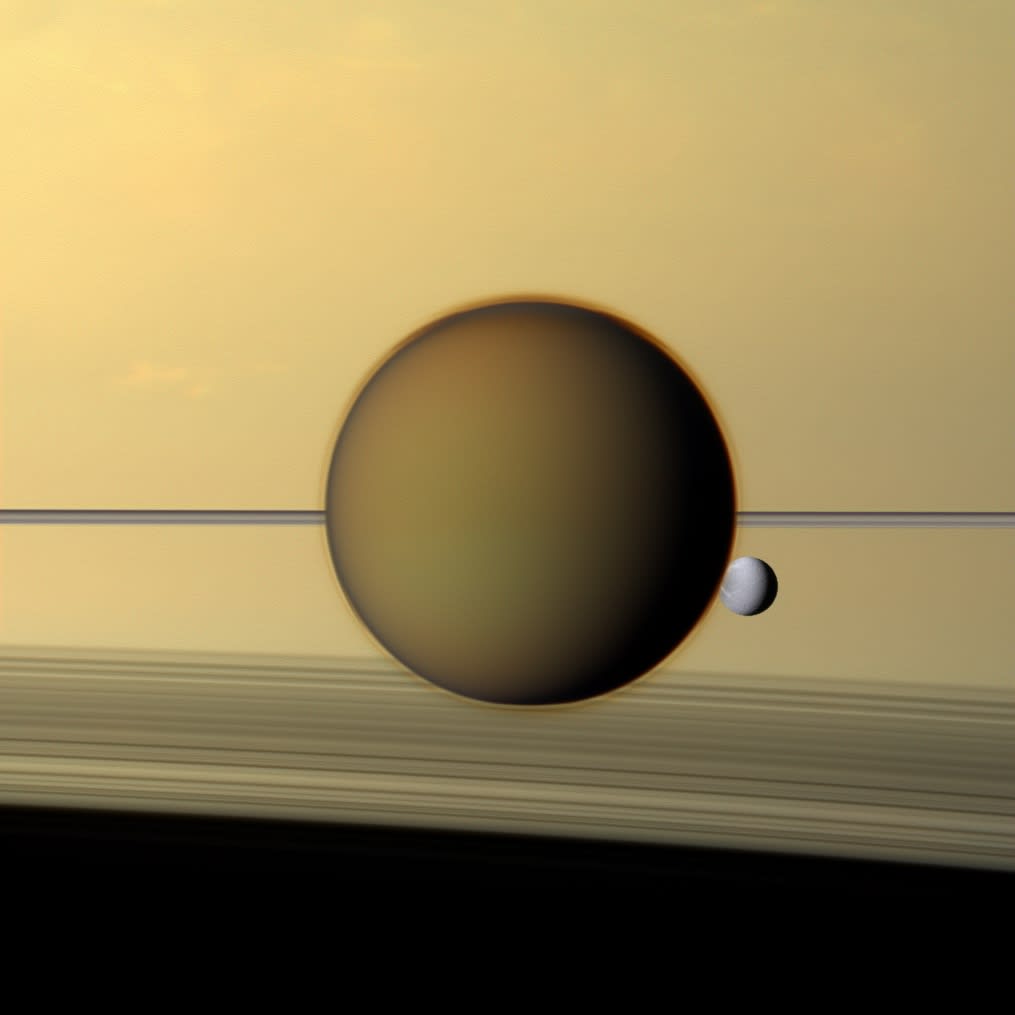 Taken just over 10 years ago, in May 2011, Saturn's fourth-largest moon, Dione, seen through the haze of the planet's largest moon, Titan, in this view of the two in front of the planet and its rings by the NASA/ESA/ASI Cassini spacecraft