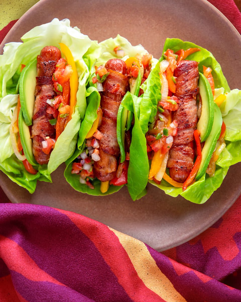 These hot dogs skip the bun but are loaded with avocado, bacon, and more, and served on lettuce leaves: