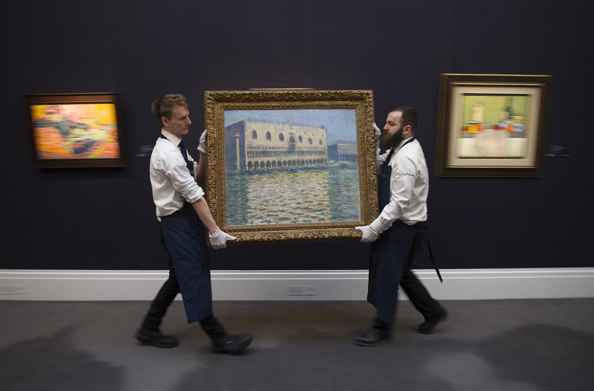 Gallery assistants adjust Le Palais Ducal by Claude Monet, during a photo call for Sotheby's Impressionist, Modern Art and Surrealist Art sales, in London Photo by: Eddie Mulholland for The Telegraph