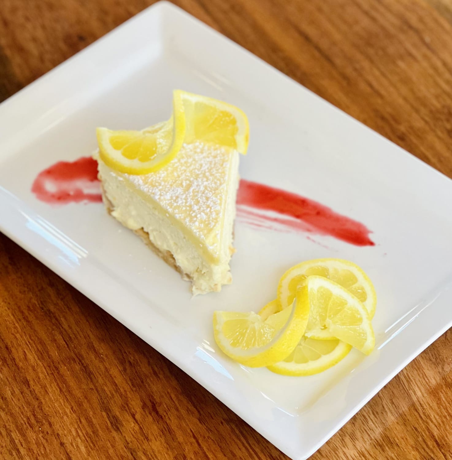 Lemon Bar Cheesecake- Shortbread cookie crust, lemon cream cheese filling topped with a lemon curd.