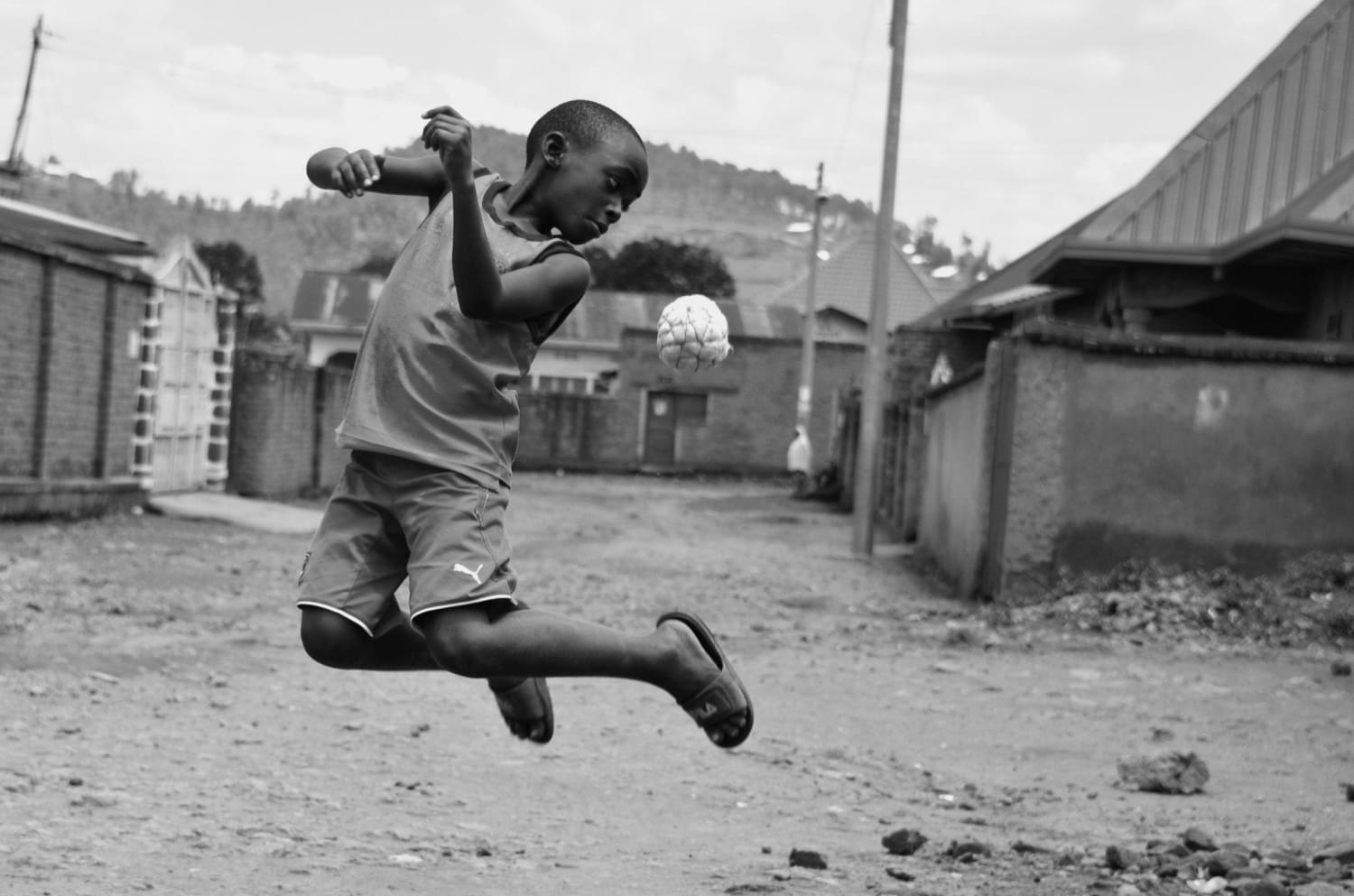 Kid playing with a local handmade football called 'karere' in the streets of Musanze, Rwanda