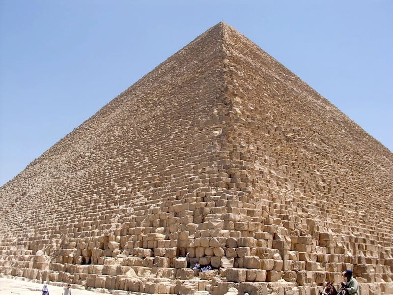 People resting under a humongous pyramid