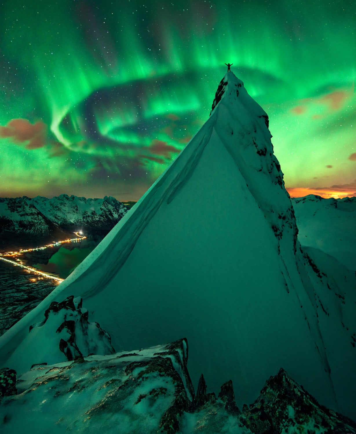 Aurora over Norway. Notice someone standing on the peak with the best view.