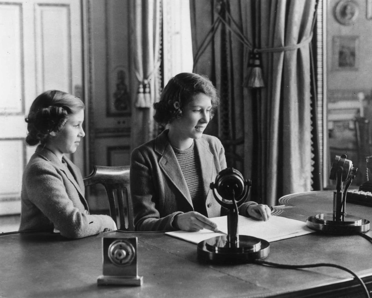 Princess Elizabeth makes her first broadcast accompanied by her sister Princess Margaret, 1940.