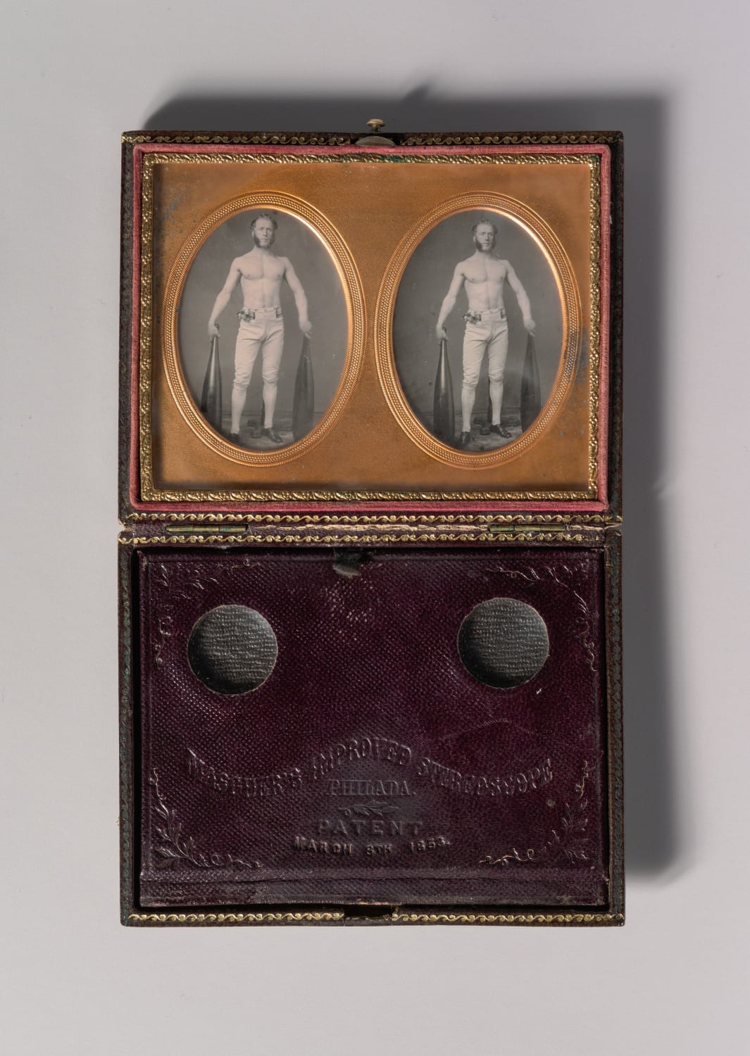 Cased stereoscopic daguerreotype photos of a strongman entertainer posing with two Indian clubs, c. 1850s. The case also has a built-in Mascher stereoscope viewer.