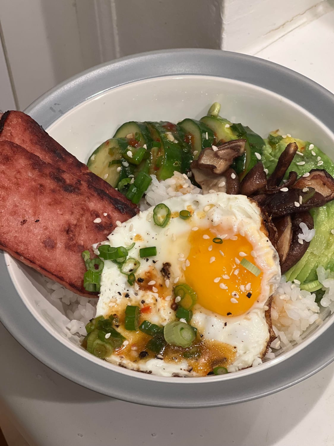 Breakfast(?) for dinner. Sushi Rice, cucumber salad, shiitake, avocado, spam, and a fried egg.