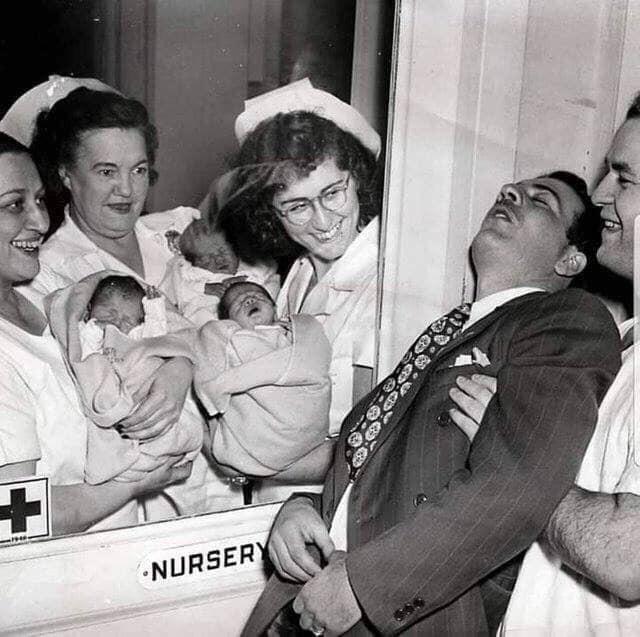 Nurses showing a set of newly born triplets to a surprised father, New York City, 1946