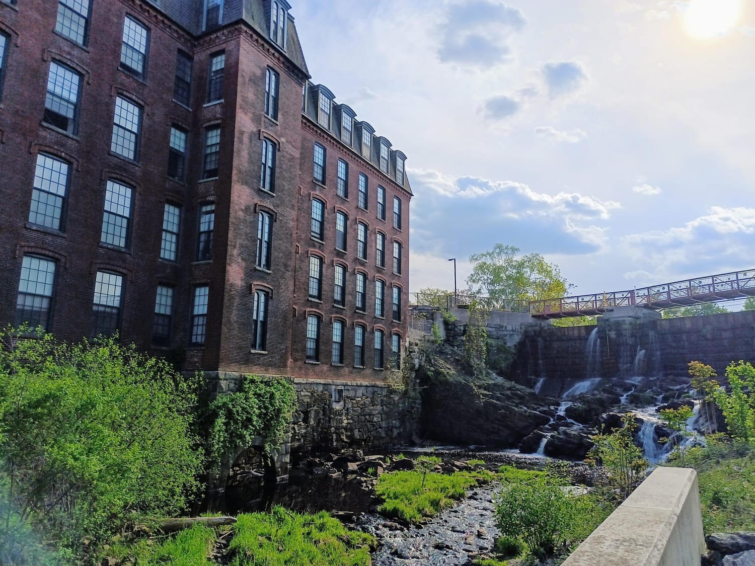 The high stone dam in Methuen Massachusetts on the Spicket River ,the old woolen mill and part of the race that it serves. Now converted to apartments