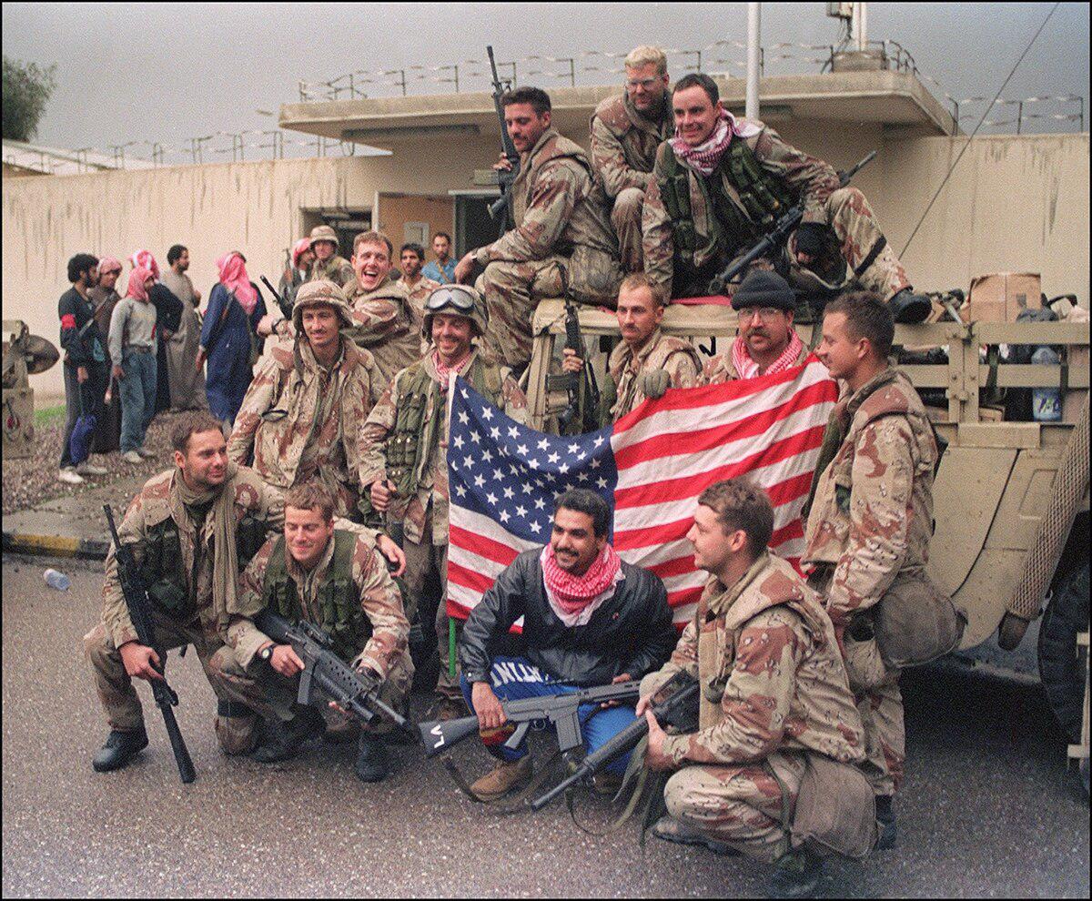 Several members of the U.S. Special Forces holding a U.S. flag celebrate their victory over the Iraqi army on Feb. 27, 1991, in Kuwait City. Posing with them, a Kuwaiti fighter with a FN FAL.