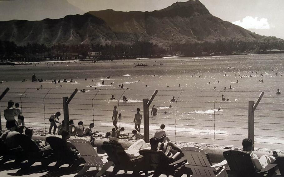 Waikiki Beach in Honolulu, Hawaii with fortified bared wires while beach goers enjoys their usual activities, c. 1942