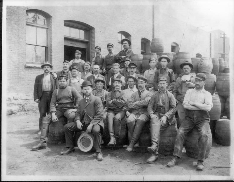 The staff of the Schade Brewery in Spokane (WA) poses in front of keg barrels (1909)
