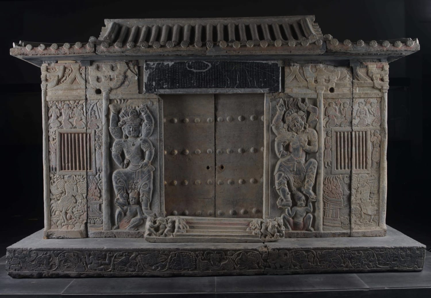 The sarcophagus of Wirkak, an 86-year-old Sogdian caravan leader, 580 CE. This Iranian culture was among the most important merchant societies on the Silk Road. The tomb imitates Chinese domestic architecture and the epitaph is bilingual. Studded doors are flanked by four-armed guards. Xi'an, China.