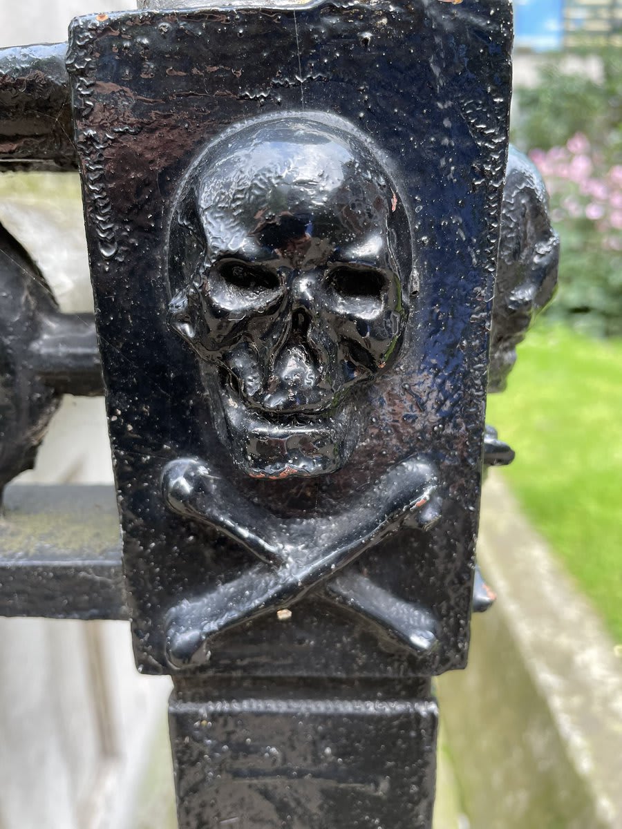 London exploring today - The tomb of Sir William Rawlins (d.1838), sheriff of London standing in the churchyard of St Botolph without Bishopsgate. The railing around features these skulls and cross bones over a torch being extinguished