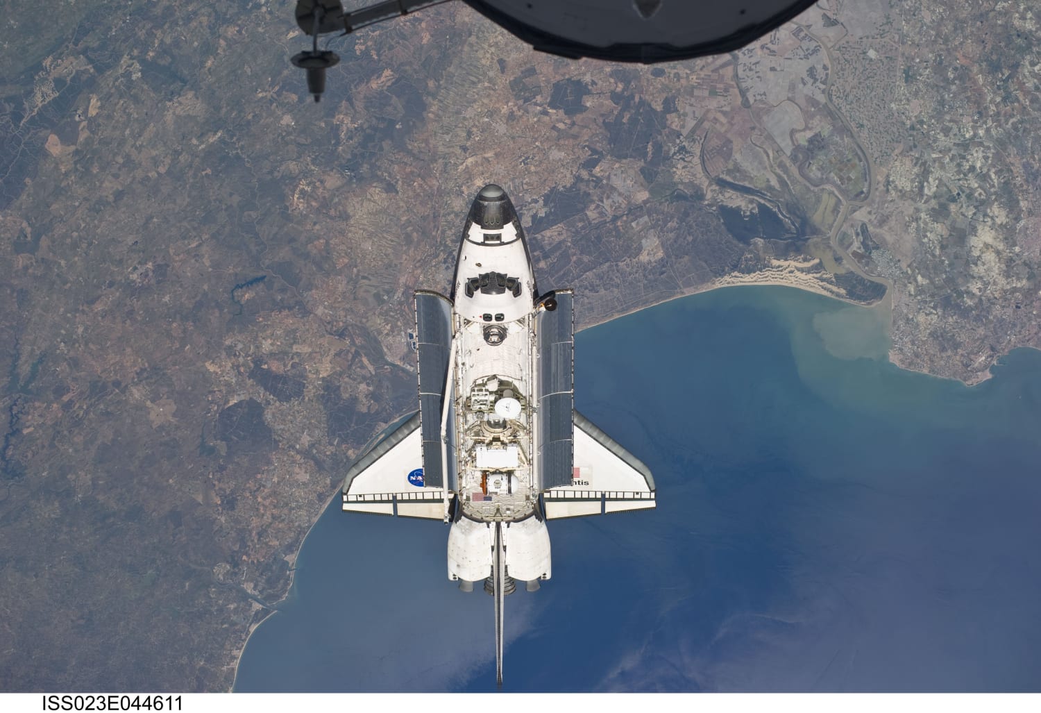 NASA's Space Shuttle Atlantis (STS-132) photographed "above the Atlantic coast of Spain and the Gulf of Cadiz" on 16 May 2010. "The coast includes the city of Ayamonte (left of image as photographed), past Huelva (under Atlantis), past the sand dunes, the Rio Guadalquivir, to the city of Rota."
