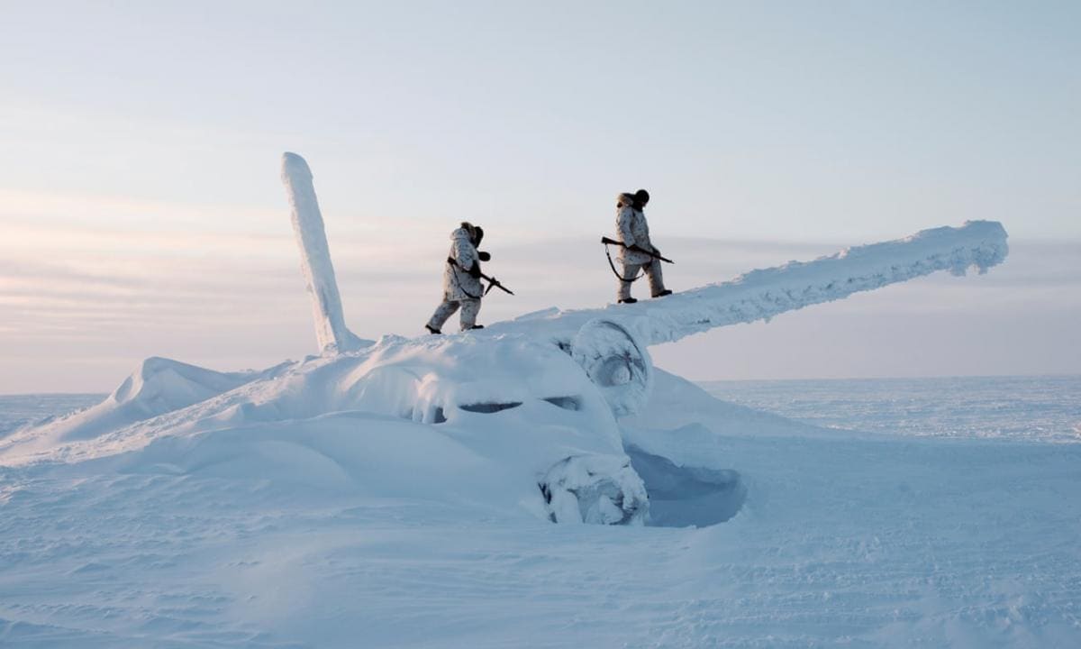 Two Canadian rangers conducting a survey mission on Cornwallis Island inspect a frozen wreckage of an aircraft that crash landed in that area many decades ago; Nunavut Territory, circa 2010s