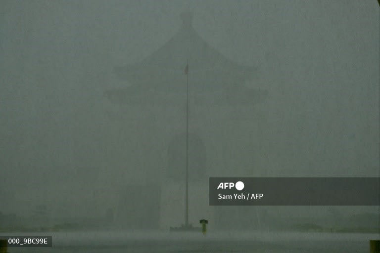 Taiwan - A man walks in heavy rain caused by Tropical Storm Choi-Wan in front of the Chiang Kai-shek Memorial Hall in Taipei. Sam Yeh