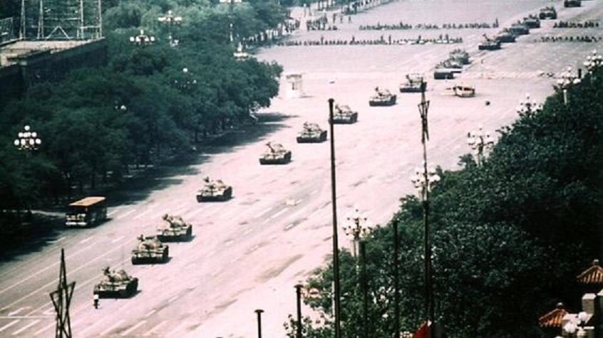 A Chinese man stands alone(bottom left)to block tanks heading east on Beijing's Cangan Blvd. in Tiananmen Square on June 5, 1989. He is calling for an end to the violence and bloodshed against pro-democracy demonstrators, was pulled away by bystanders, and the tanks continued on their way.