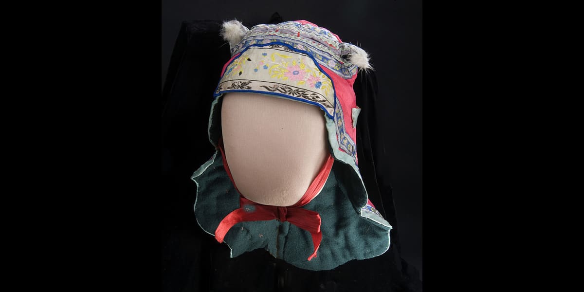 Lee Ng Shee made this bonnet for her son in 1919. Chinese mothers traditionally dressed their one year old children in “dog head” bonnets like this one to protect them from evil spirits. Mrs. Lee grew up in China before immigrating to New York, where she raised seven children.