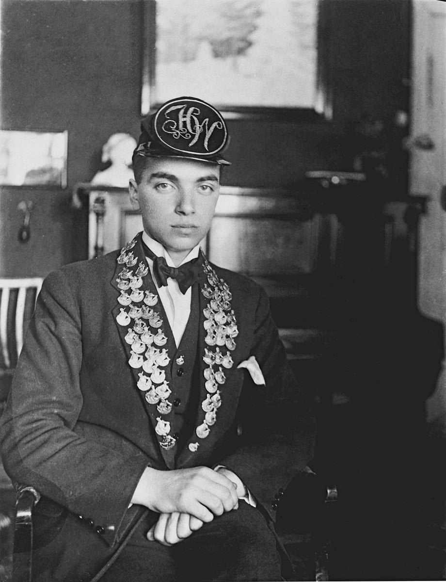 Close-up portrait of Hans Georg Wolff, Germany, circa 1930. The pins on his lapels a portrait of Duke Albrecht. Known as an "Albertus," this pin was traditionally worn in East Prussia to indicate that the wearer had passed their high school exams.