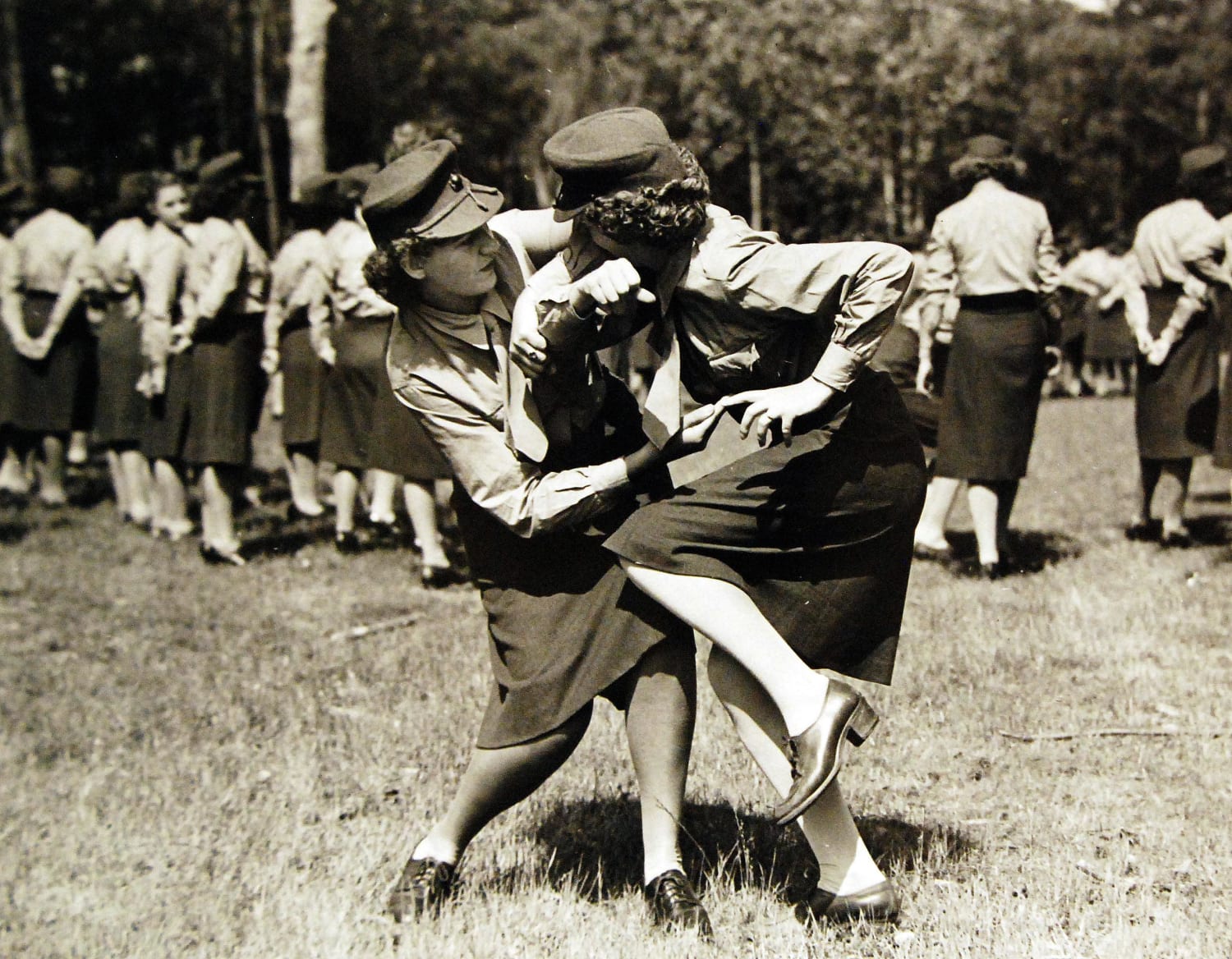 June 18, 1943: How to disable an armed opponent is demonstrated by two girl Marines in training at Camp Lejeune, New River, North Carolina. The Marines with their backs to the camera are watching another display of feminine skill in the art of self-defense.