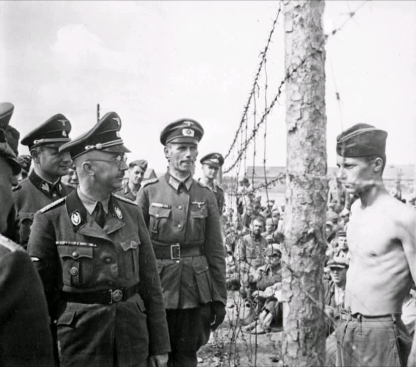 Head of the SS, Heinrich Himmler, accompanied by an entourage of SS and Army personnel, inspects a prison camp for Soviet prisoners-of-war in occupied Minsk, August 1941.