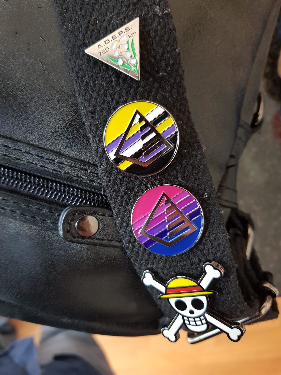 Bi and Enby pride pins I designed and got made. The prism with six stripes symbolizes the rainbow flag.