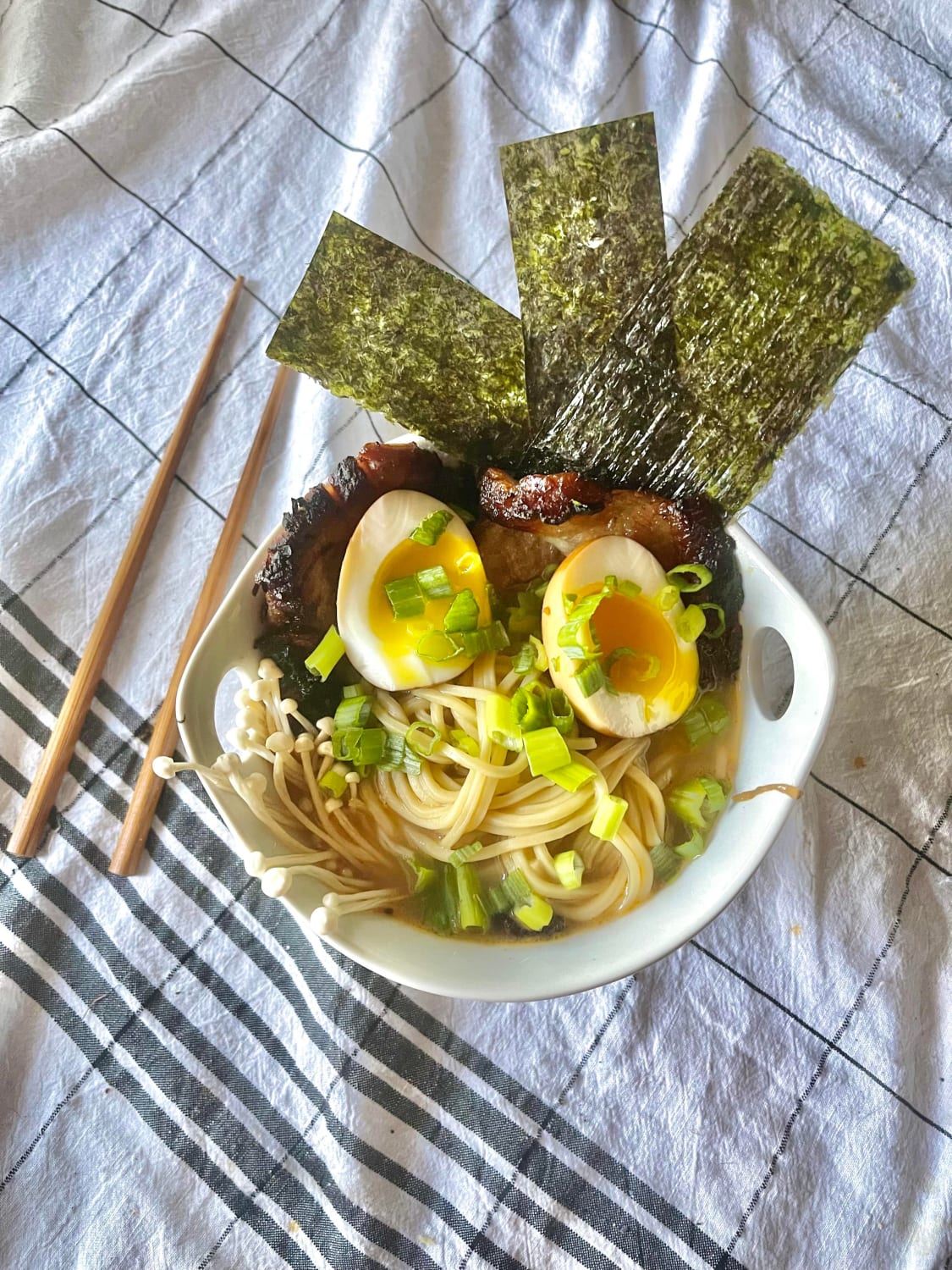 Homemade Ramen I made! Noodles in a broth made with homemade vegetable stock and marinade from the also pictured chashu pork. Topped with soy marinaded soft boiled eggs, nori, enoki mushrooms, and scallions.