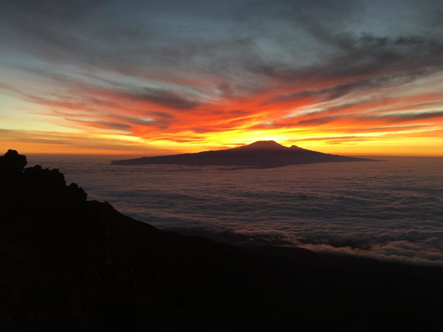 Tanzanian Sunrise looking at Kilimanjaro from Mt Meru over the clouds