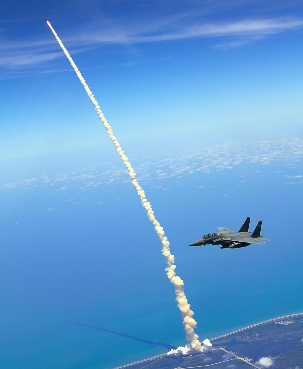 An F-15E Strike Eagle patrols the skies as the Space Shuttle Atlantis launches (May 14th, 2010)