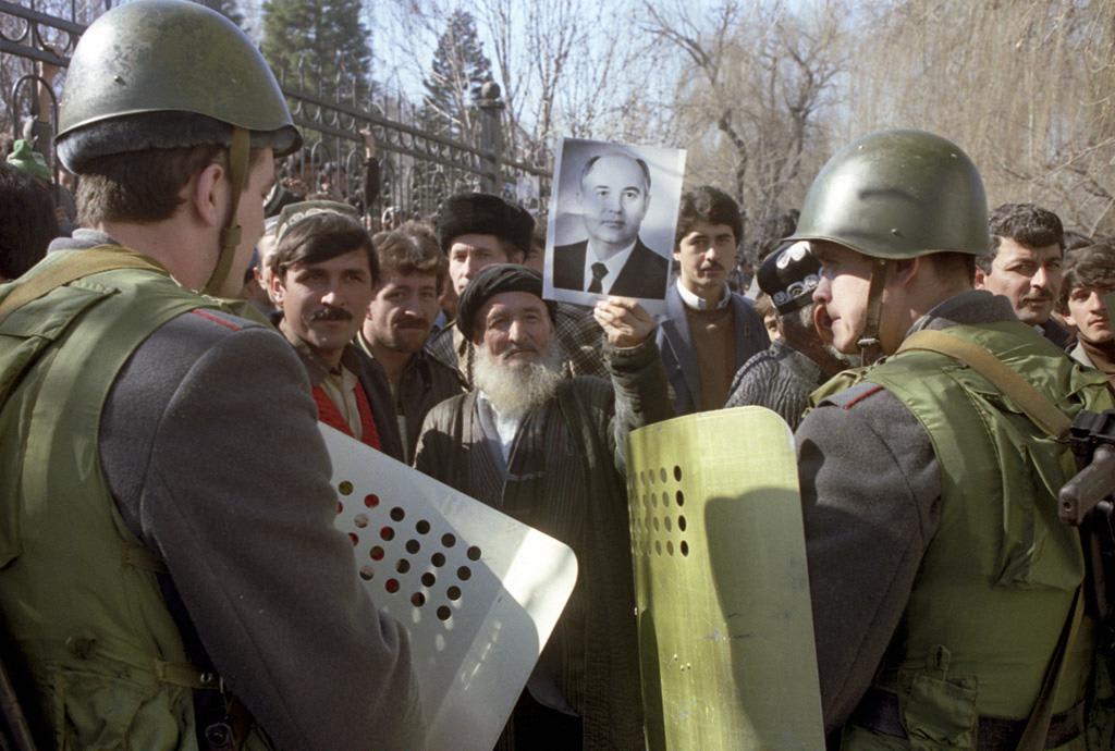 Elderly Tajik man holding picture of CPSU Secretary General Mikhail Gorbachev during mass demonstrations and riots in then-Soviet republic's capital, city of Dushanbe. February 15, 1990