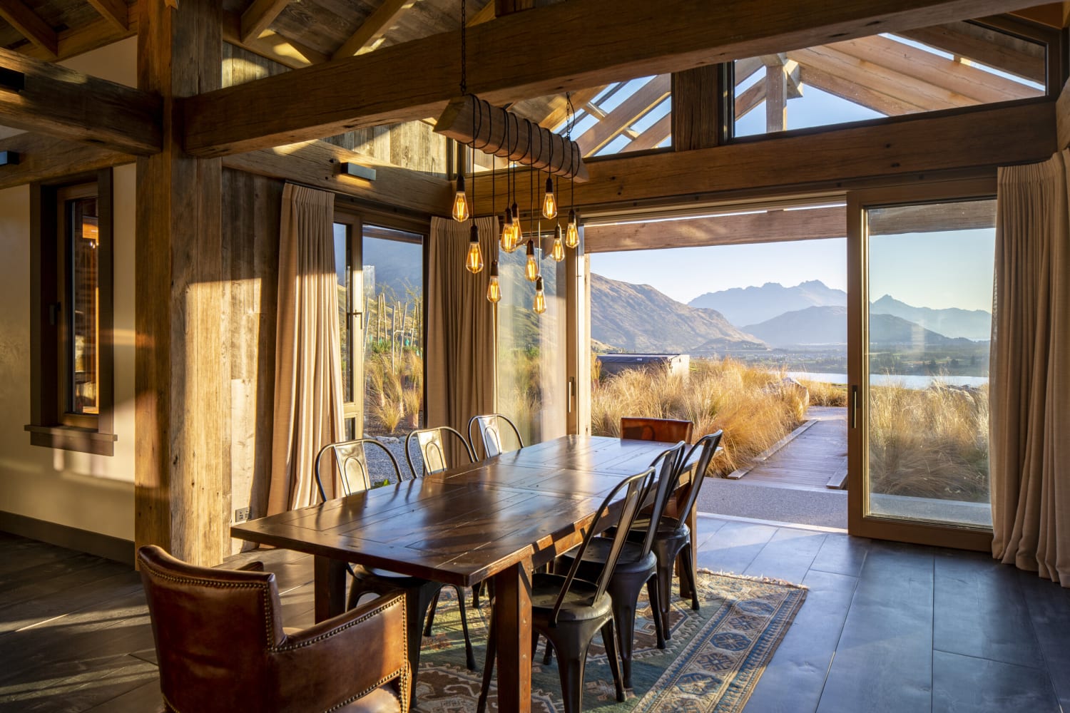Upcycled dining room with views of Lake Hayes, New Zealand, by Mason and Wales Architects