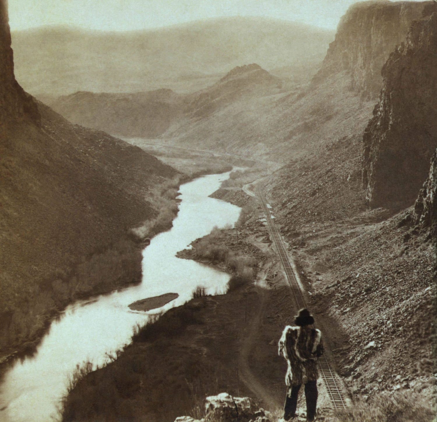 A native American man looking over the newly completed transcontinental railroad in Nevada, 1869.