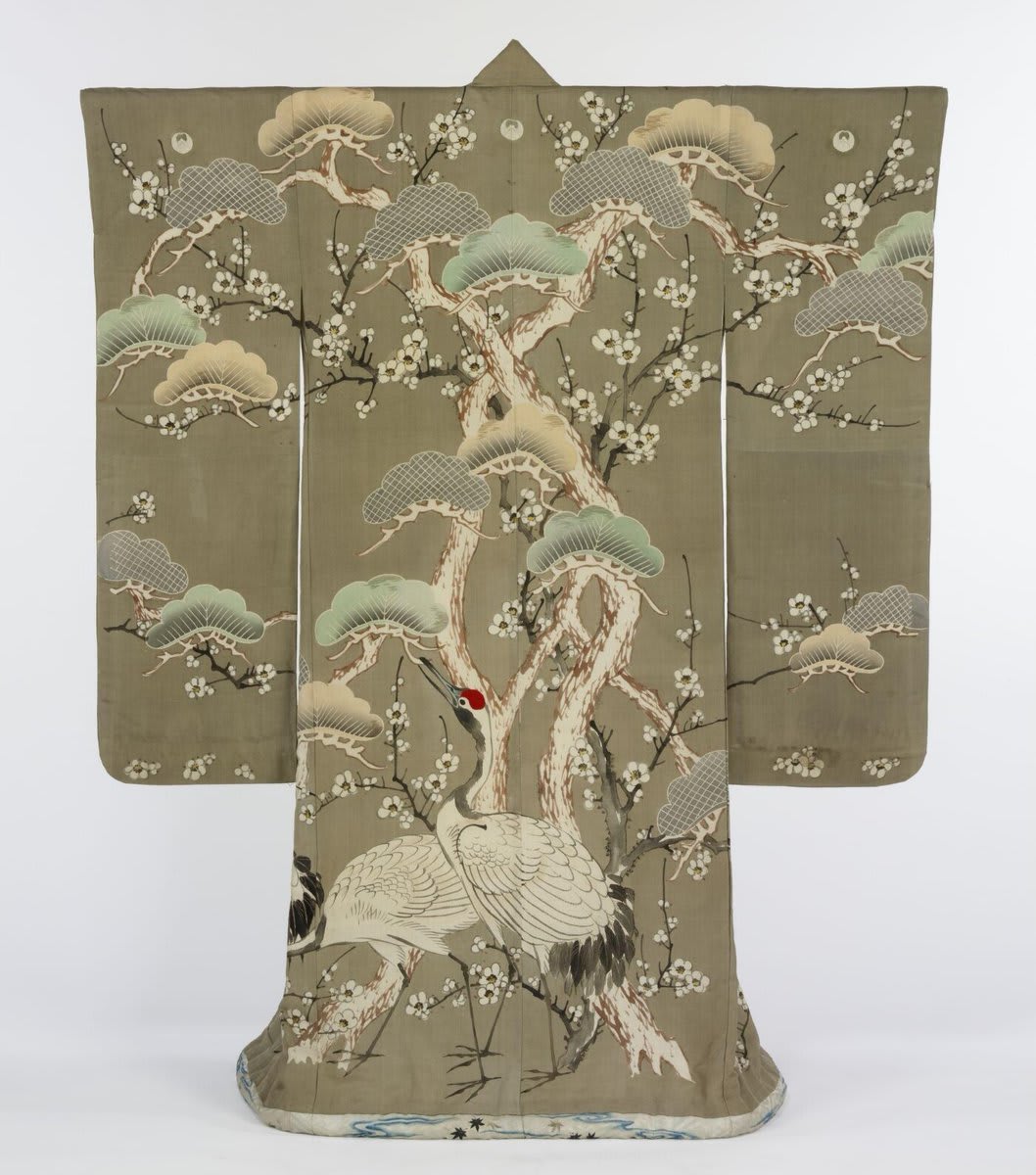 This stunning 19th century kimono illustrates the close connection between painting and textiles in Japan. The surface of the garment acts as a scroll for the hand-painted cranes and plum blossoms. Discover More: