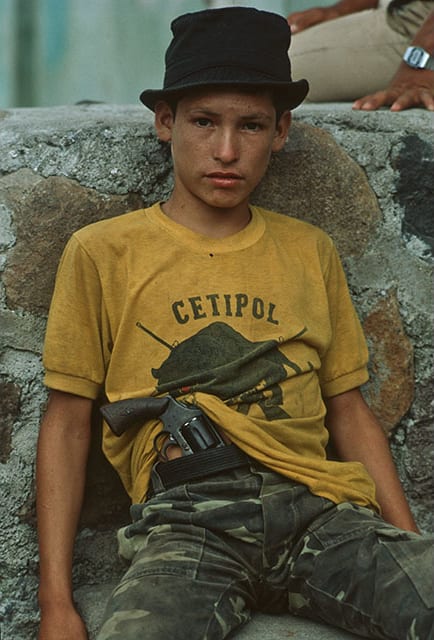 A child soldier from the Panther Batallion of the Salvadoran National Police in the town of Suchitoto, during the counter-insurgency operative Fénix. Salvadoran Civil War, 1986.