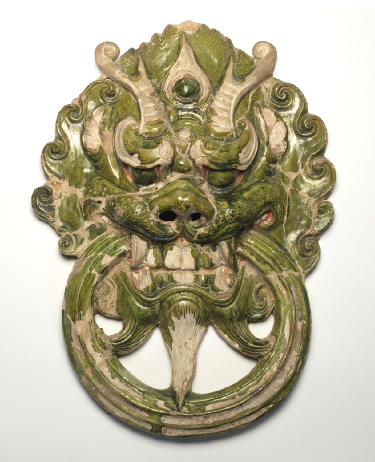 Ceramic tomb ornament shaped like a dragon head holding a ring. China, Tang dynasty, 618 - 906