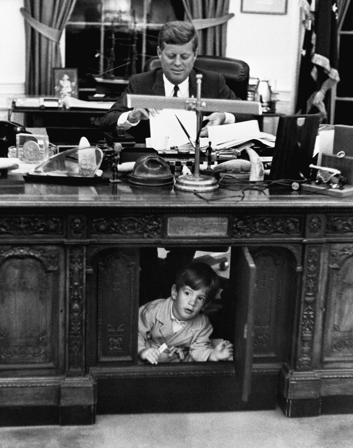 John F. Kennedy Jr. Exploring His Father's Desk In The Oval Office On October 10, 1962
