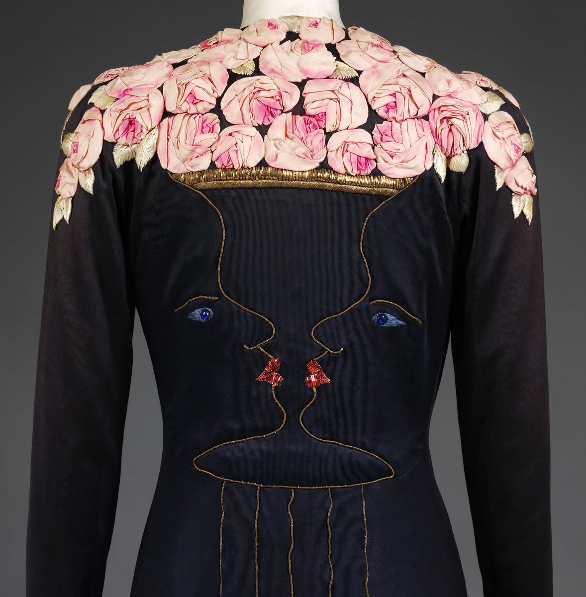 What can you see, a vase of roses or two faces? Elsa Schiaparelli was one of the most prominent fashion designers in the 1920s-1940s. This evening coat was the result of a magnificent collaboration with Jean Cocteau.